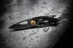 Stainless Steel Blade Folding Knife Laying Open on Dark Wet Surface, lifestyle photo